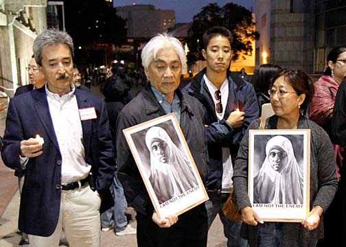 Participants in the vigil at the Japanese American National Museum plaza hold copies of my poster, "I Am Not The Enemy." Photo by Mark Vallen ©.