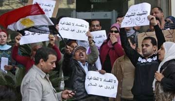 State museum workers in Egypt hold a protest for higher wages on Feb. 9, 2011. Rallying in front of the Supreme Council of Antiquities, the workers were confronted by Zahi Hawass. Some of the signs read, "No to corruption, no to oppression," and "Increase Pay." AP Photo/Ben Curtis.